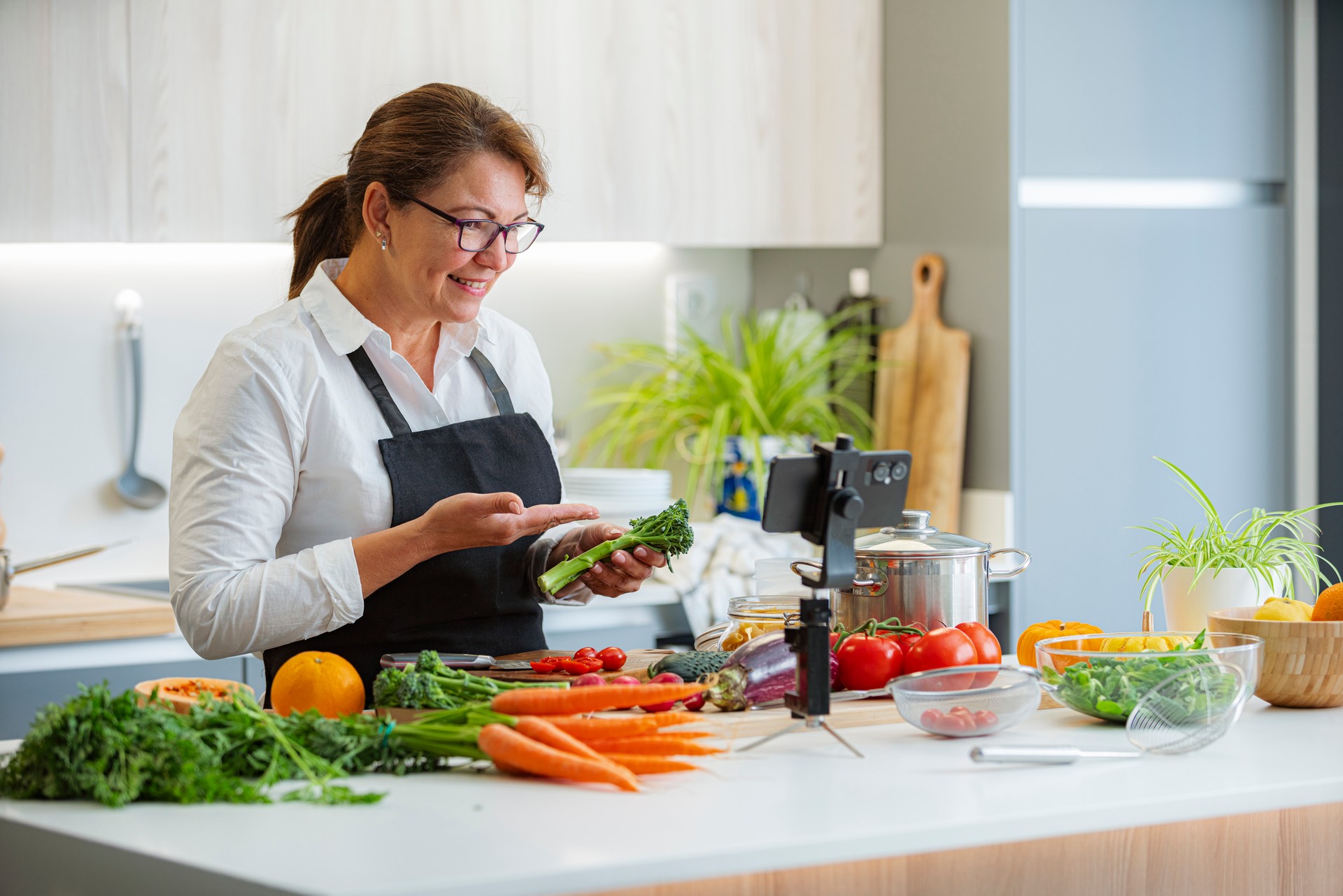 Mature woman cooking healthy vegan food and srtreaming masterclass lesson. Healthy eating class